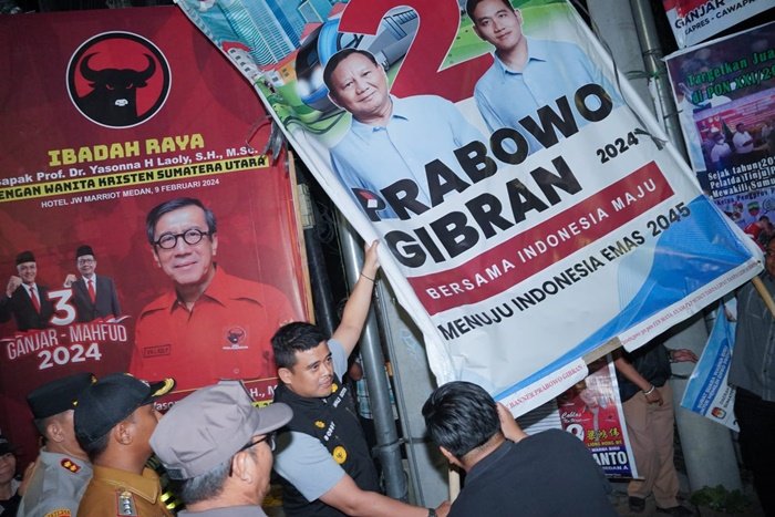 Penurunan baliho pasangan calon (paslon) presiden dan wakil presiden nomor urut 2, Prabowo Subianto dan Gibran Rakabuming Raka dan sejumlah calon legislatif (caleg) yang dilakukan langsung Wali Kota Medan Bobby Nasution di persimpangan Jalan Putri Hijau dan Gurupatimpus, Minggu (11/2) dinihari, sebagai simbolis dimulainya penertiban Alat Peraga Kampanye (APK) di seluruh Kota Medan menyusul masuknya masa tenang. (seputaranindonesia.com/istimewa)